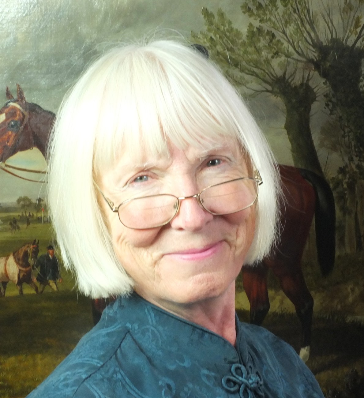 Rosalind Whitehouse in front of a sporting painting of horses